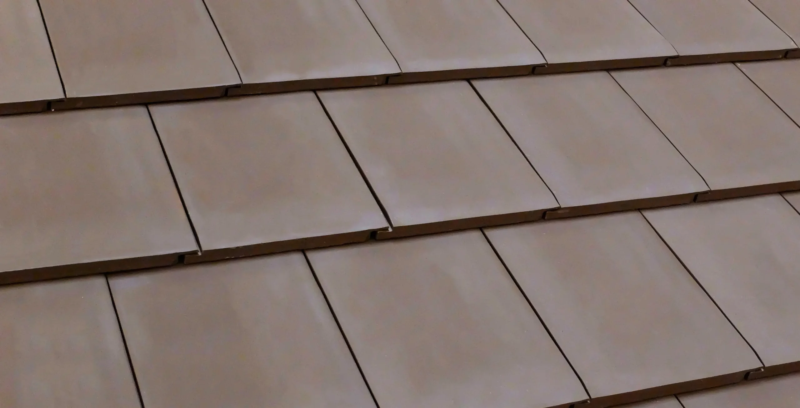 Close-up of brown ceramic roof tiles arranged in overlapping rows Brown ceramic roof tiles overlapping pattern