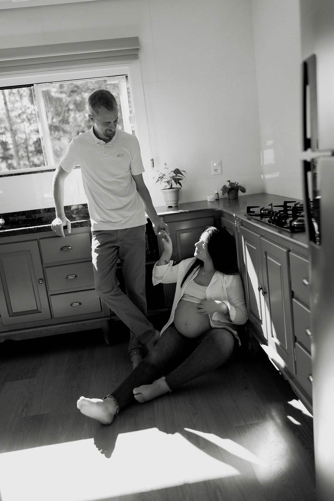 Expectant couple sharing a quiet moment in their kitchen during an in-home maternity session