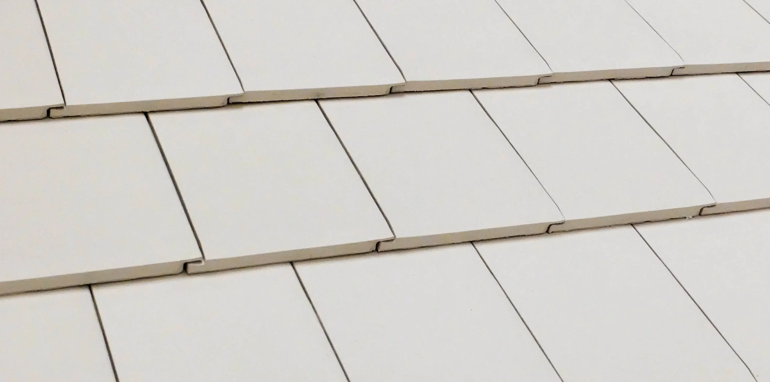 Close-up of white ceramic roof tiles arranged in rows White ceramic roof tiles in rows