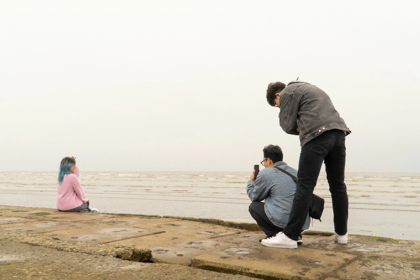 Photographer capturing a portrait of a woman on the beach