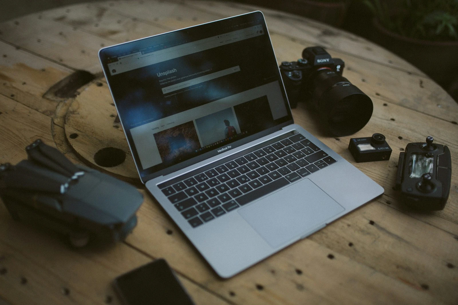 Laptop and DSLR camera laid out on a photographer's desk